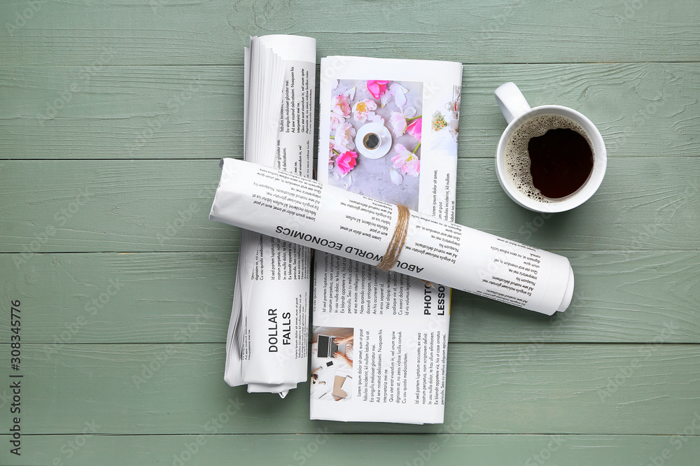 Newspapers and cup of coffee on wooden background