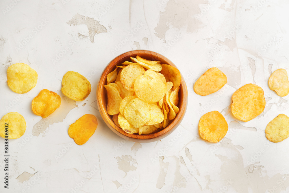 Bowl with tasty potato chips on table