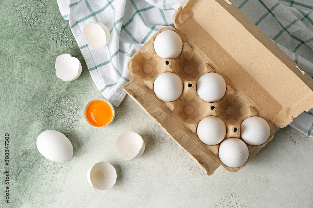 Box with fresh raw eggs on table