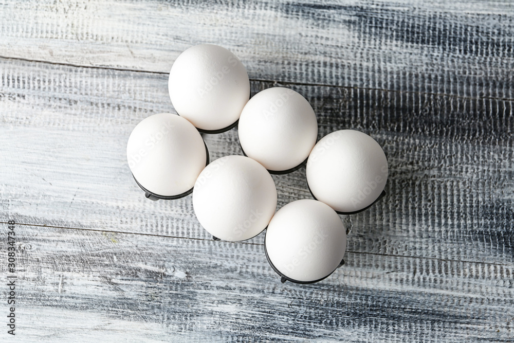 Holder with fresh raw eggs on table