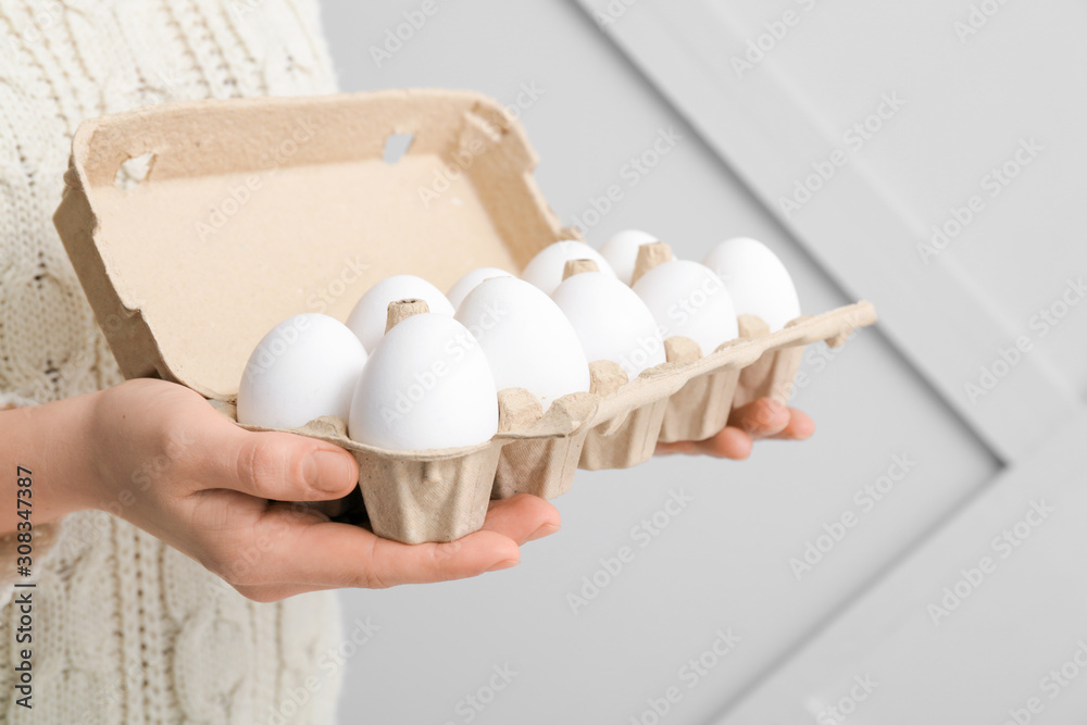 Woman with box of fresh raw eggs, closeup