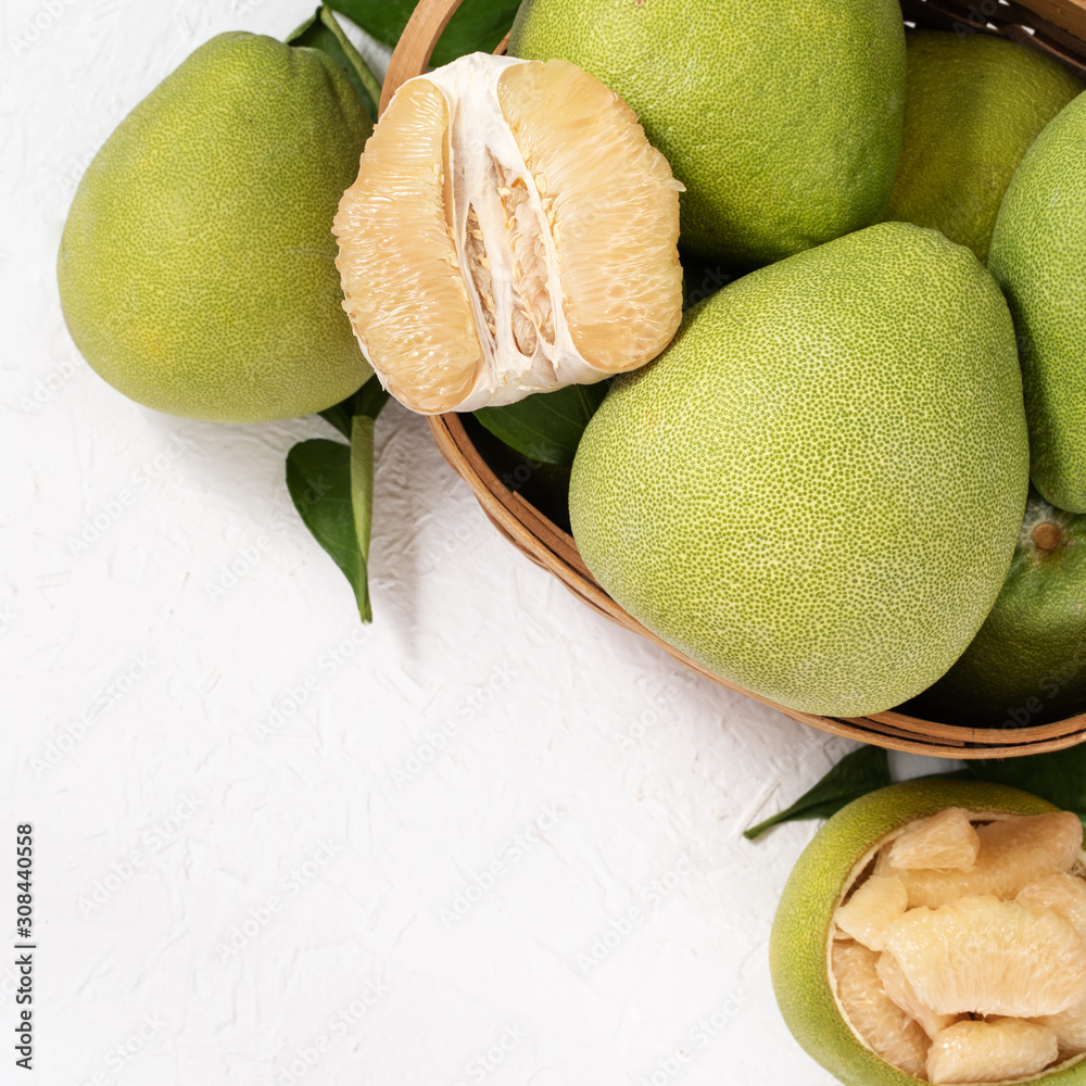 Fresh peeled pomelo, pummelo, grapefruit, shaddock on bright wooden background. Autumn seasonal frui