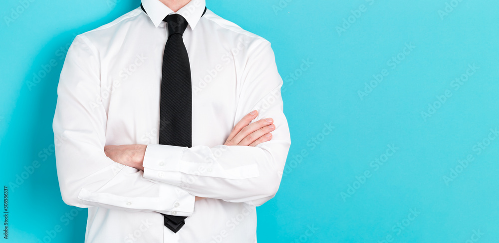 Businessman crossing his arms on blue background