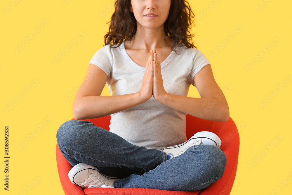 Beautiful woman meditating on color background