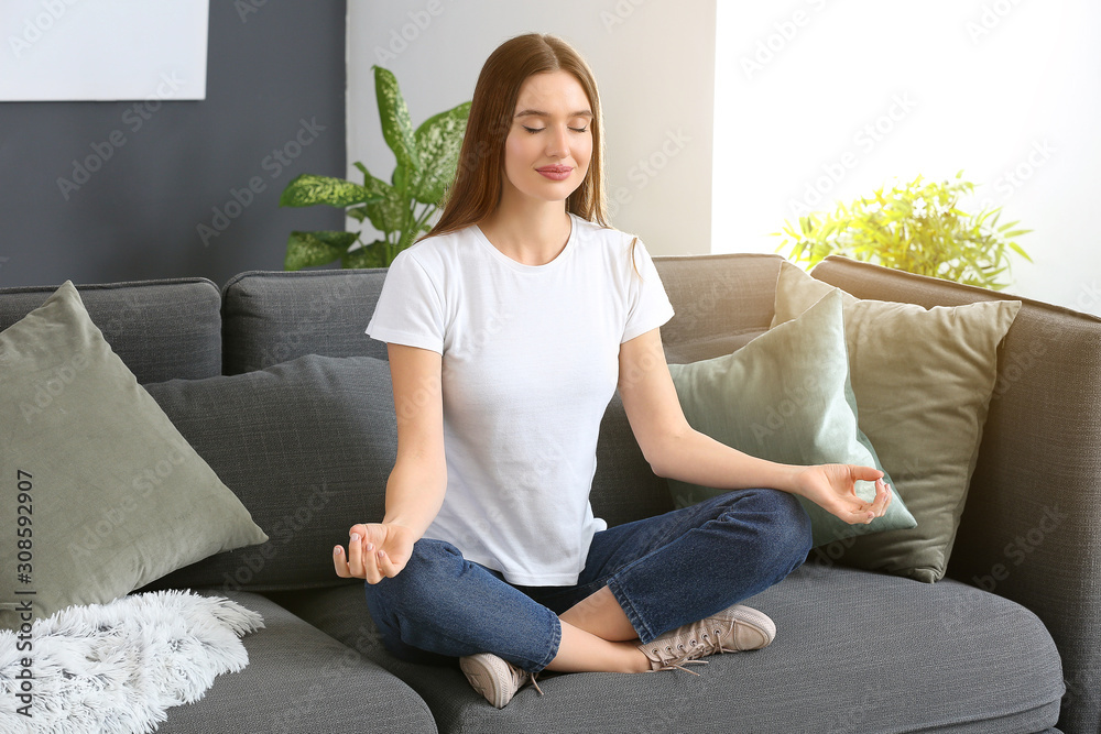 Beautiful woman meditating at home