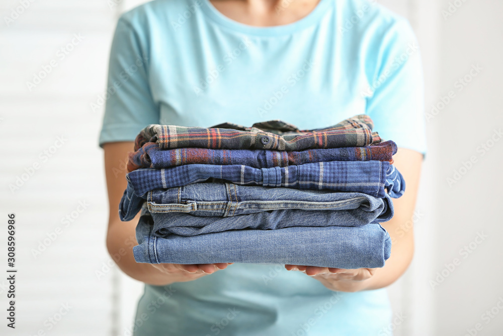 Woman with stack of clean clothes, closeup