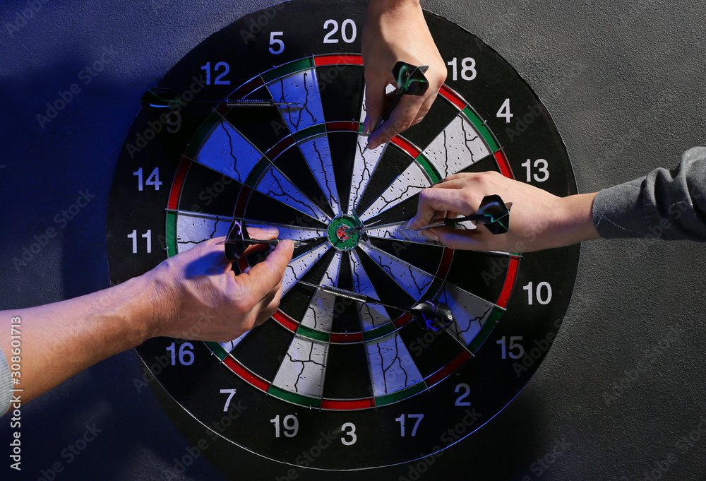 People taking darts out of dartboard