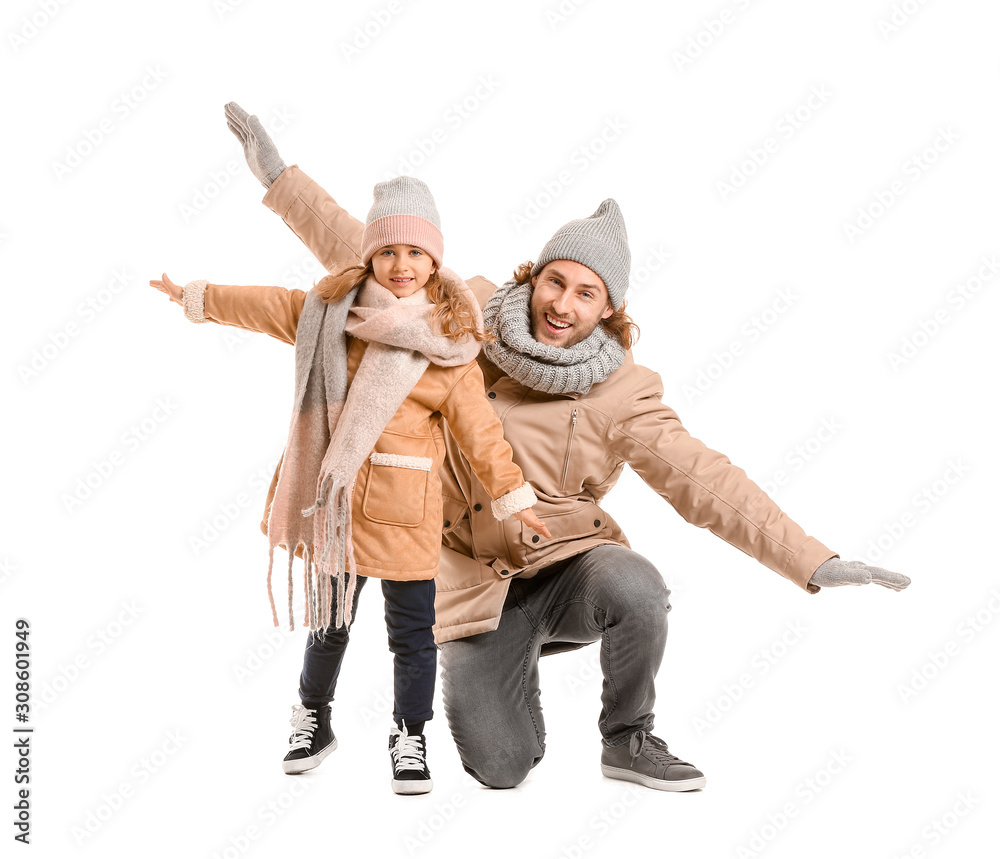 Handsome man and his little daughter in winter clothes on white background