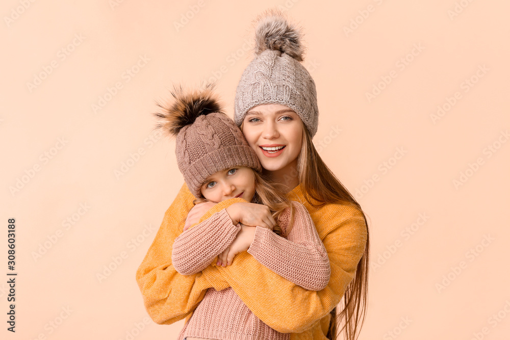 女人和她的小女儿穿着彩色背景的冬装