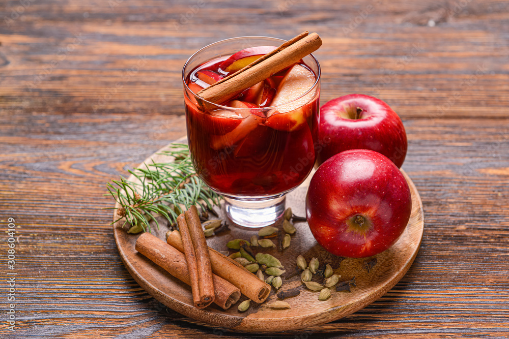 Glass of tasty mulled wine on wooden table