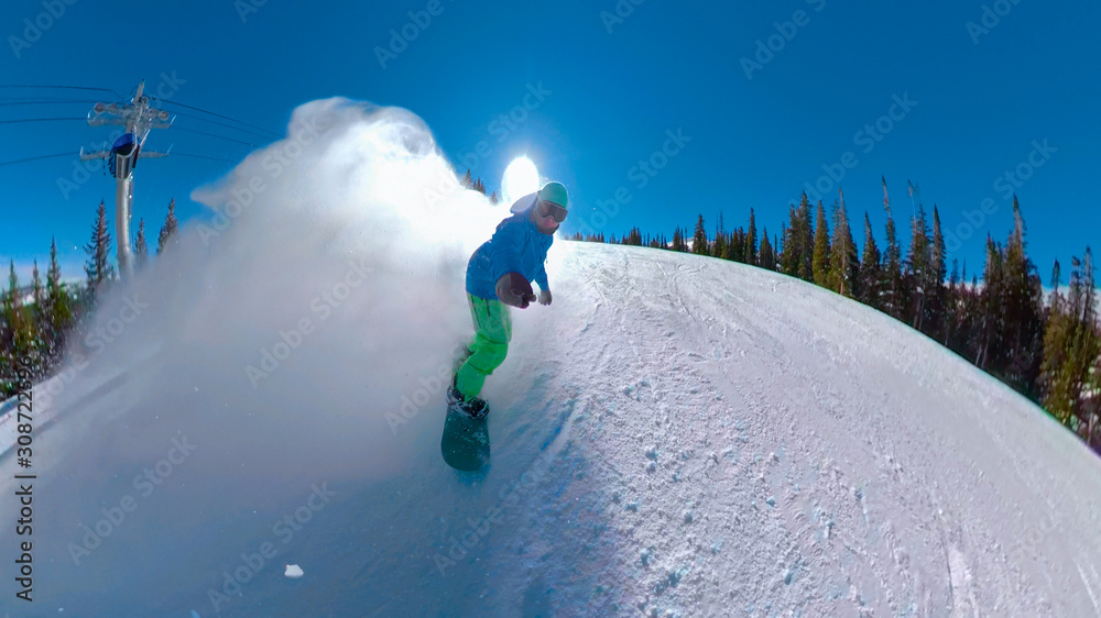 SELFIE: Snowboarder sprays snow while carving down the neatly groomed trail.