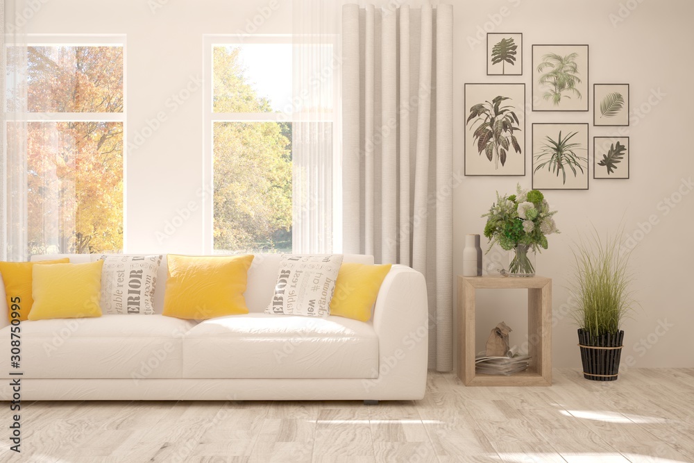 Stylish room in white color with sofa and autumn landscape in window. Scandinavian interior design. 