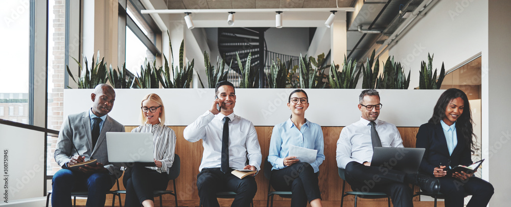 Smiling group of diverse businesspeople waiting in an office rec