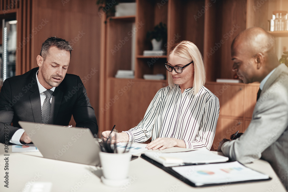 Diverse businesspeople meeting together around a boardroom table