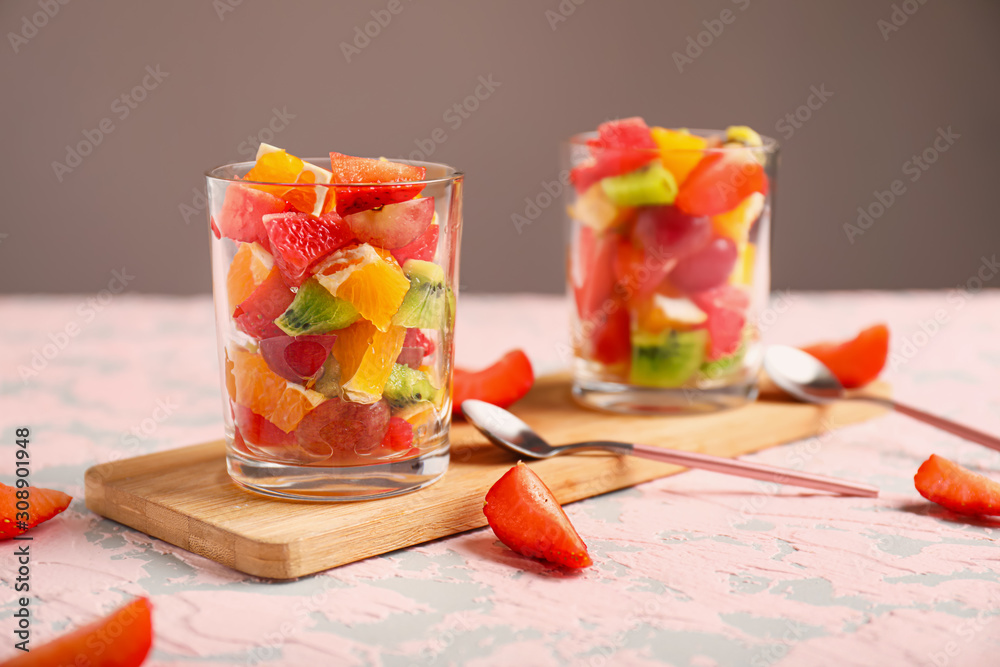 Glasses with tasty fruit salad on table