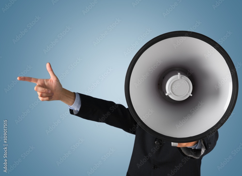 Young businessman talking on the megaphone on background