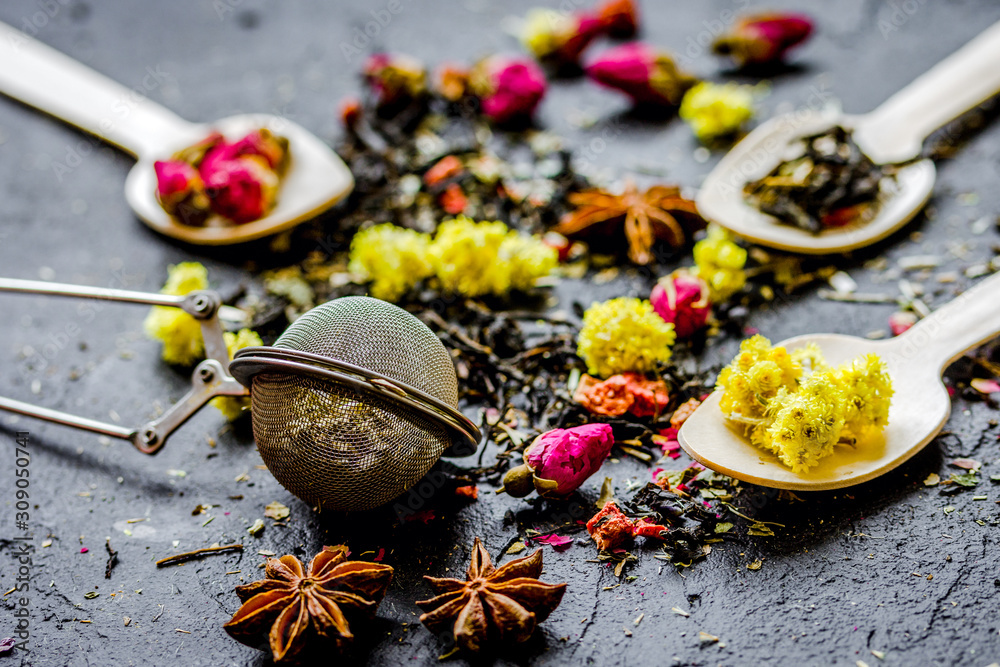 Tea herbs and spoons on grey background