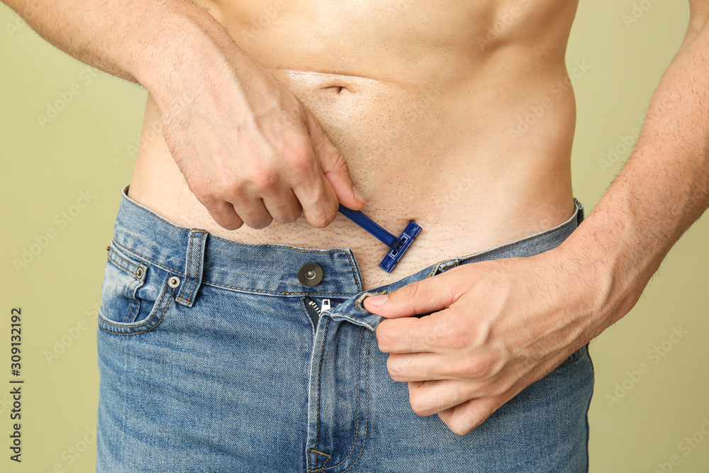 Handsome young man shaving his body on color background, closeup