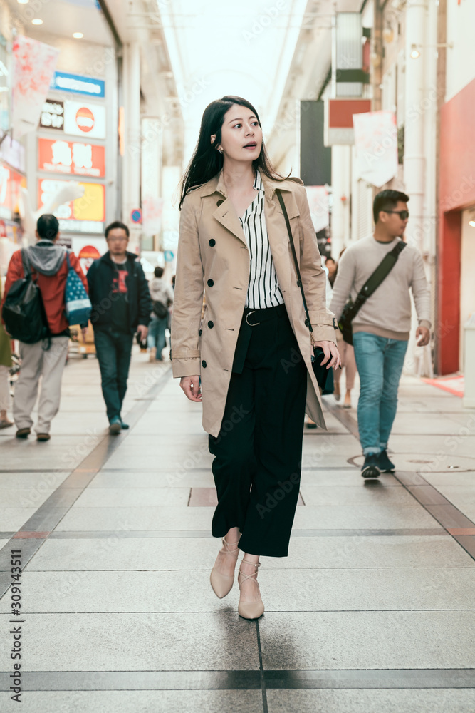 full length of beautiful young woman on business trip to osaka japan shopping in shinsaibashi. offic