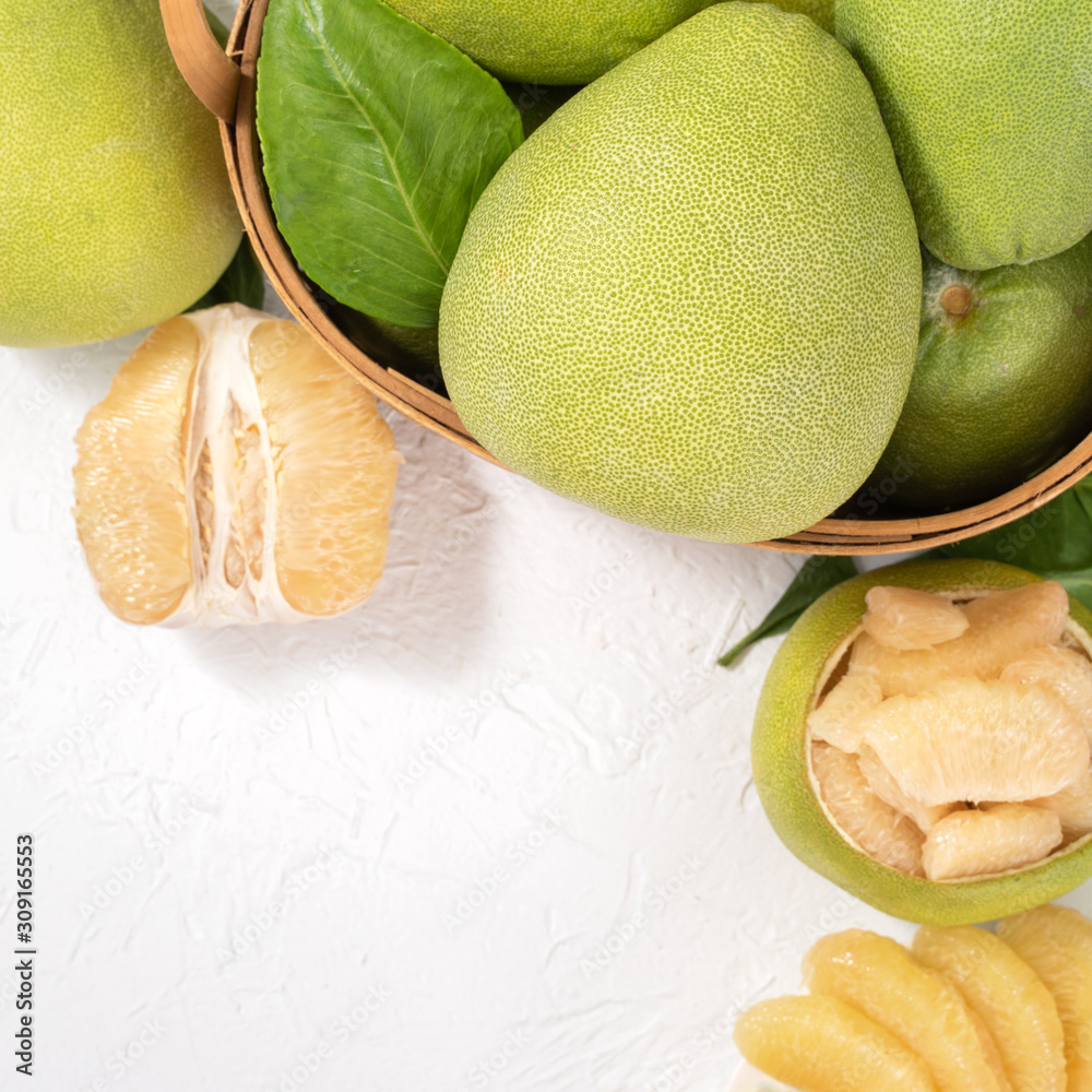 Fresh peeled pomelo, pummelo, grapefruit, shaddock on bright wooden background. Autumn seasonal frui