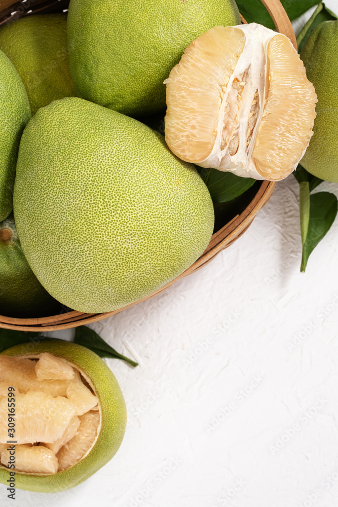 Fresh peeled pomelo, pummelo, grapefruit, shaddock on bright wooden background. Autumn seasonal frui