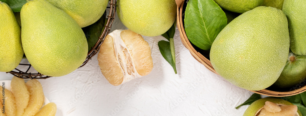 Fresh peeled pomelo, pummelo, grapefruit, shaddock on bright wooden background. Autumn seasonal frui