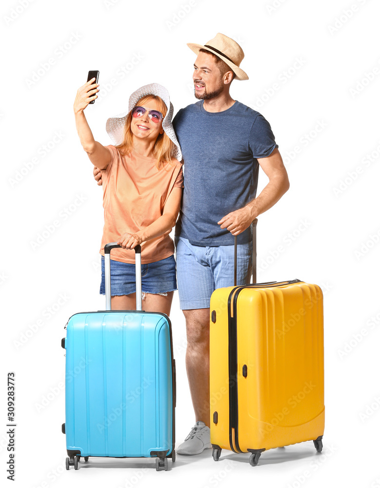 Couple with suitcases taking selfie on white background