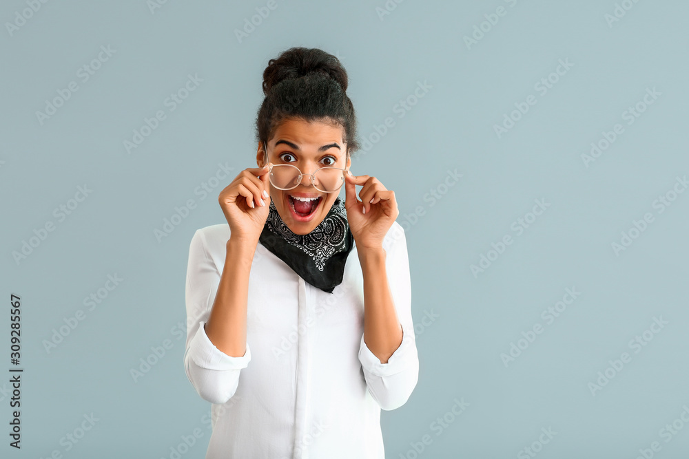 Surprised African-American woman on grey background