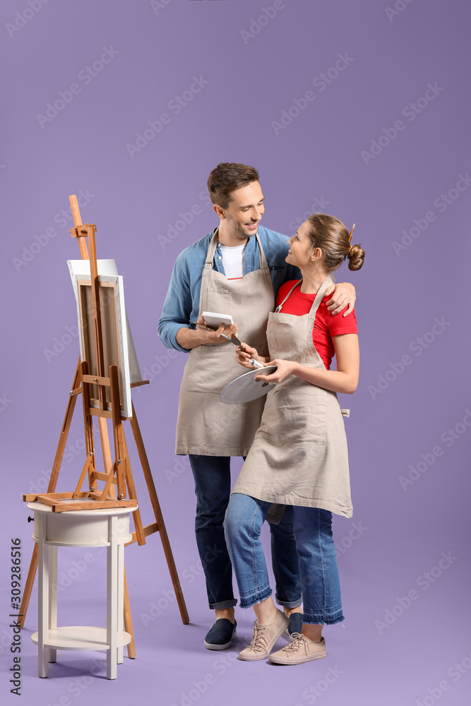 Couple of young artists on color background