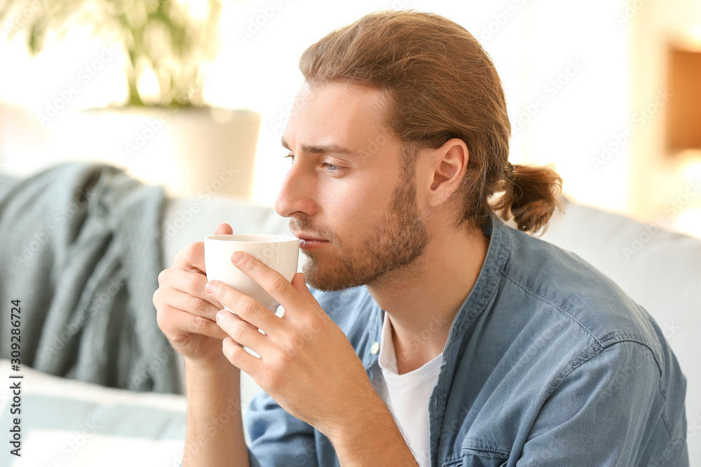 Handsome man drinking coffee at home