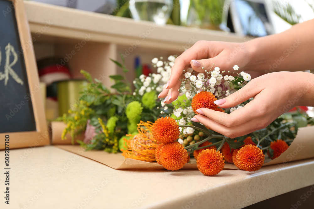 Florist making beautiful bouquet in shop, closeup