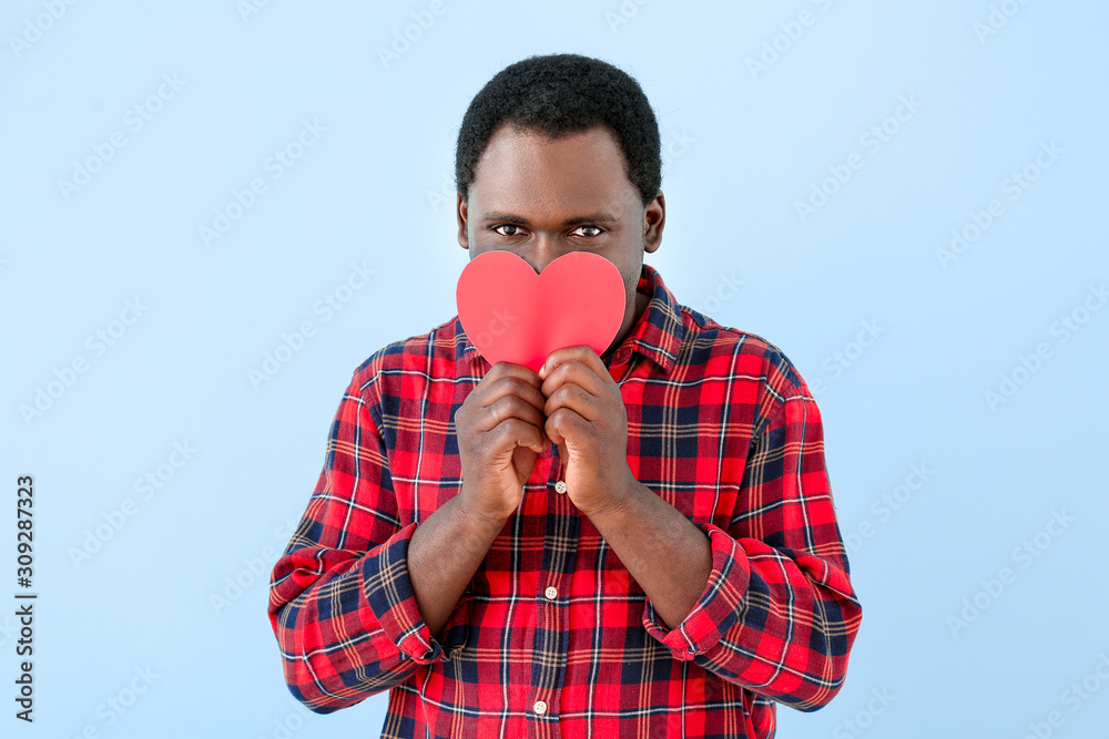 African-American man with red heart on color background