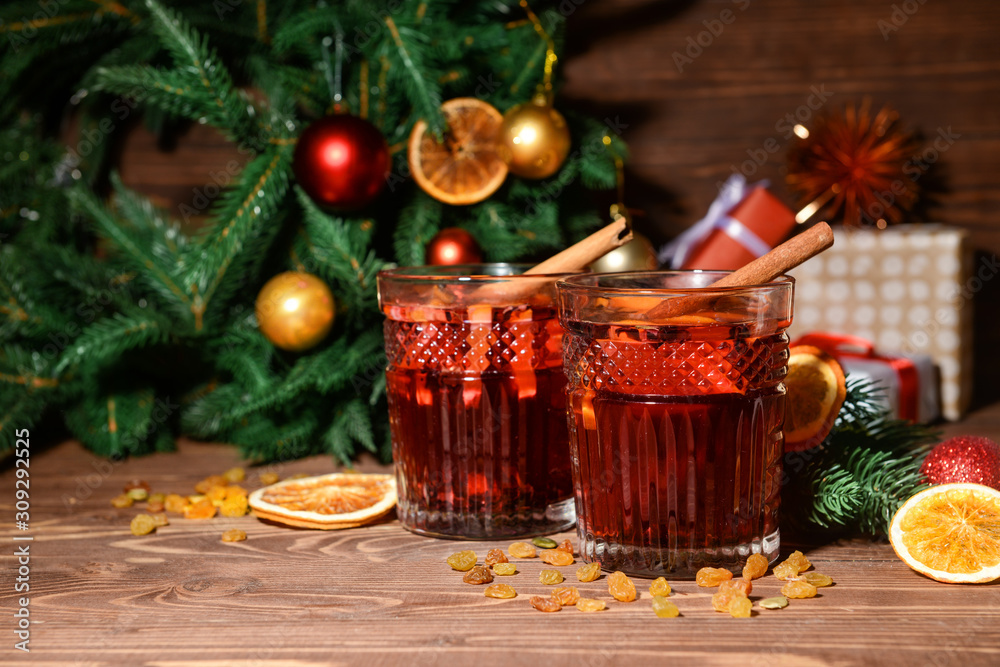 Glasses of tasty mulled wine on wooden table