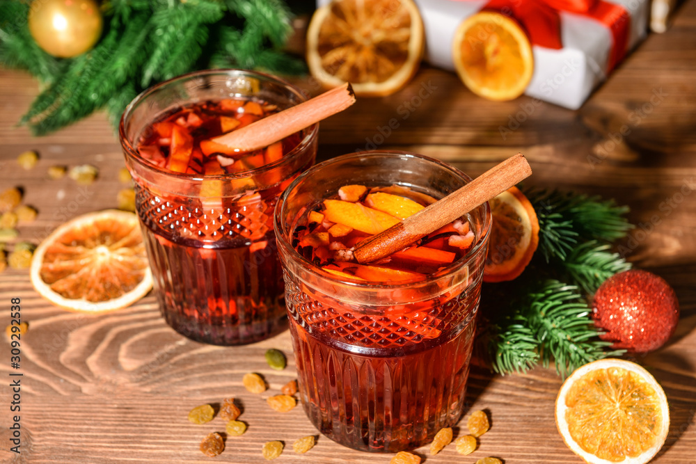 Glasses of tasty mulled wine on wooden table