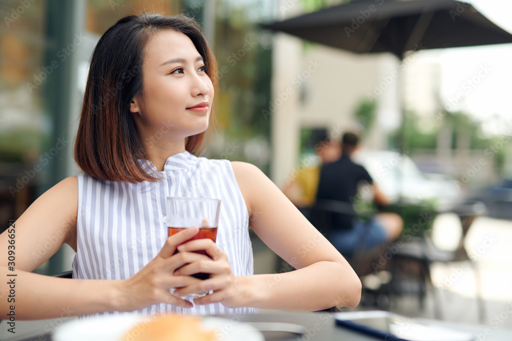 年轻女孩在她最喜欢的咖啡馆喝早上的咖啡。