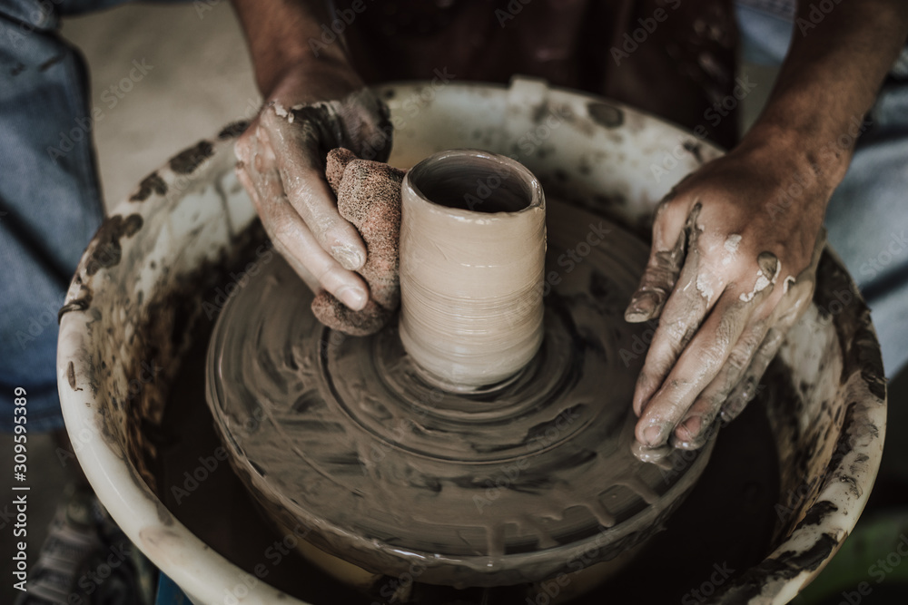 Hands of craftsman artist working on pottery wheel.Selective Focus .