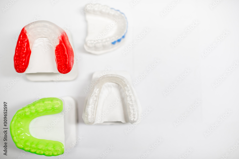 Gypsum models of artificial jaw with dental caps on the white background. Orthodontic caps and boxin