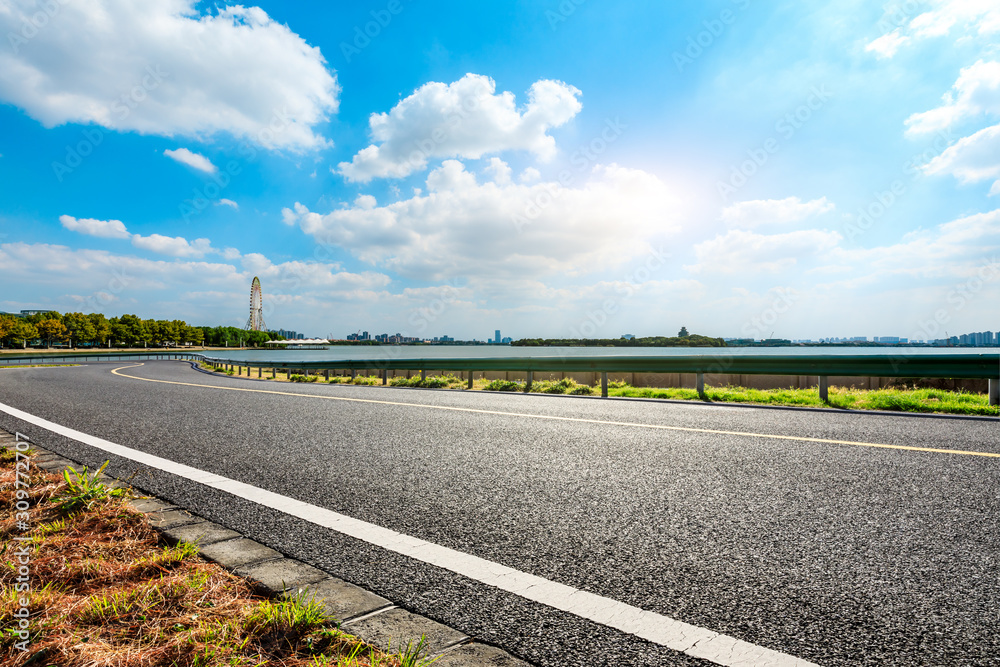 Empty asphalt highway and Suzhou city skyline on a sunny day.