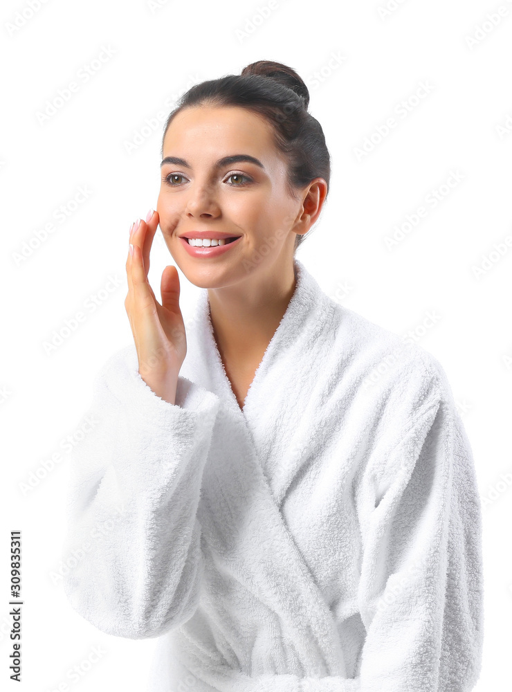 Beautiful young woman in bathrobe on white background