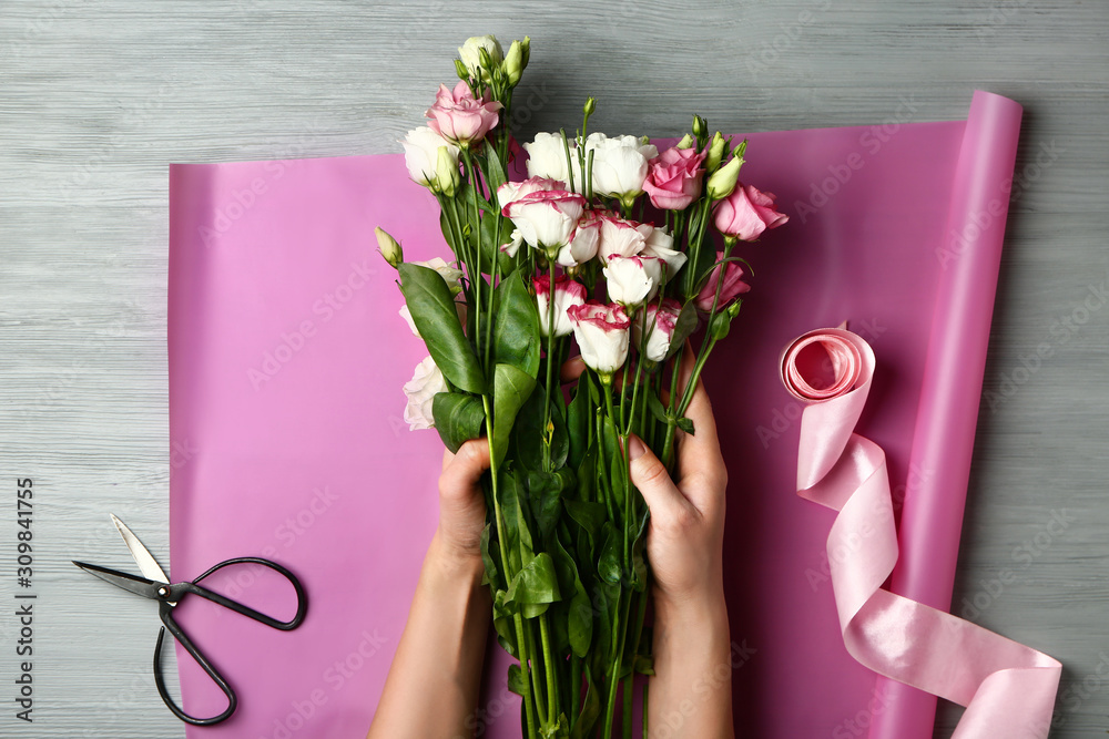 Female florist making beautiful bouquet at table