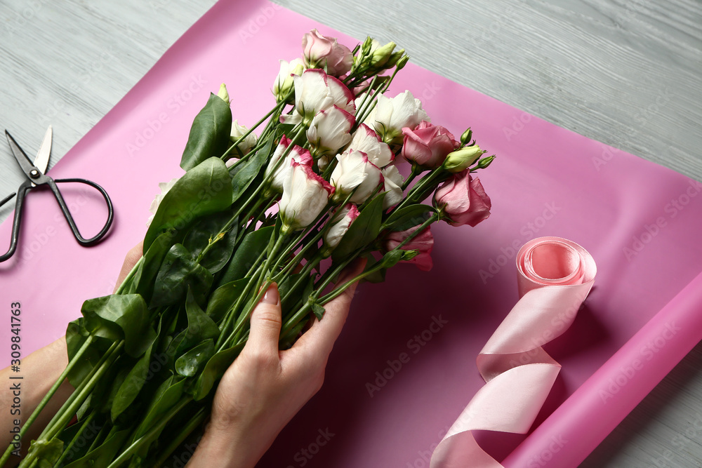 Female florist making beautiful bouquet at table