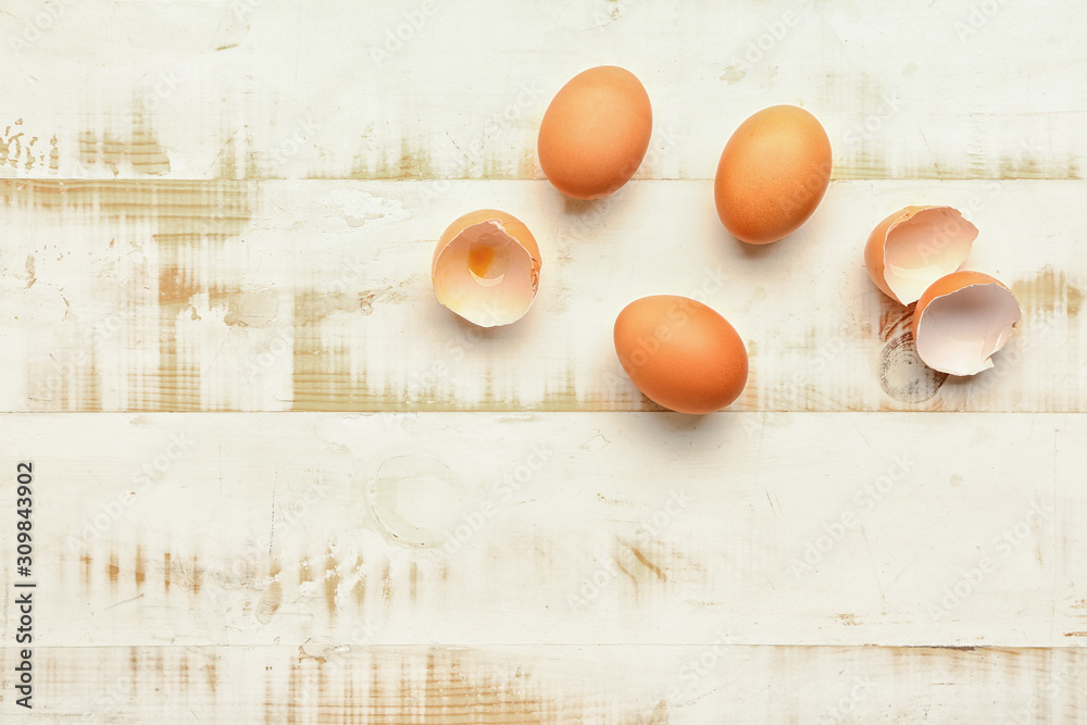 Fresh eggs on white wooden background