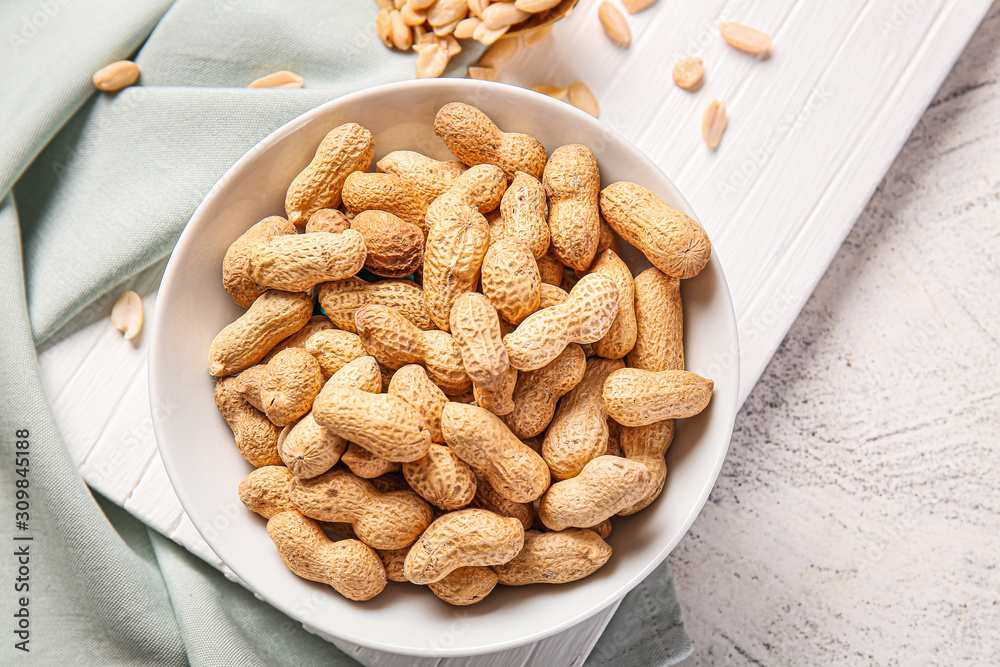 Bowl with peanuts on table