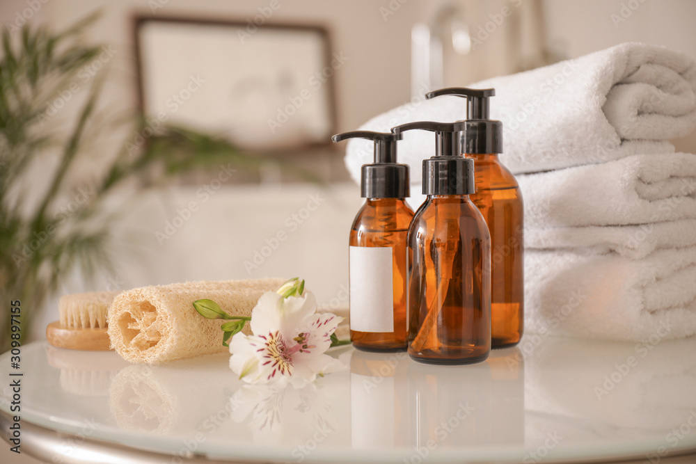 Clean towels with cosmetics and supplies on table in bathroom