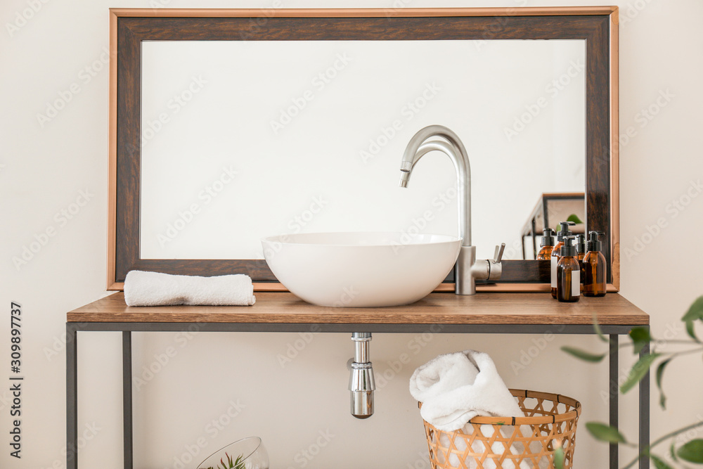 Interior of clean bathroom with sink near white wall