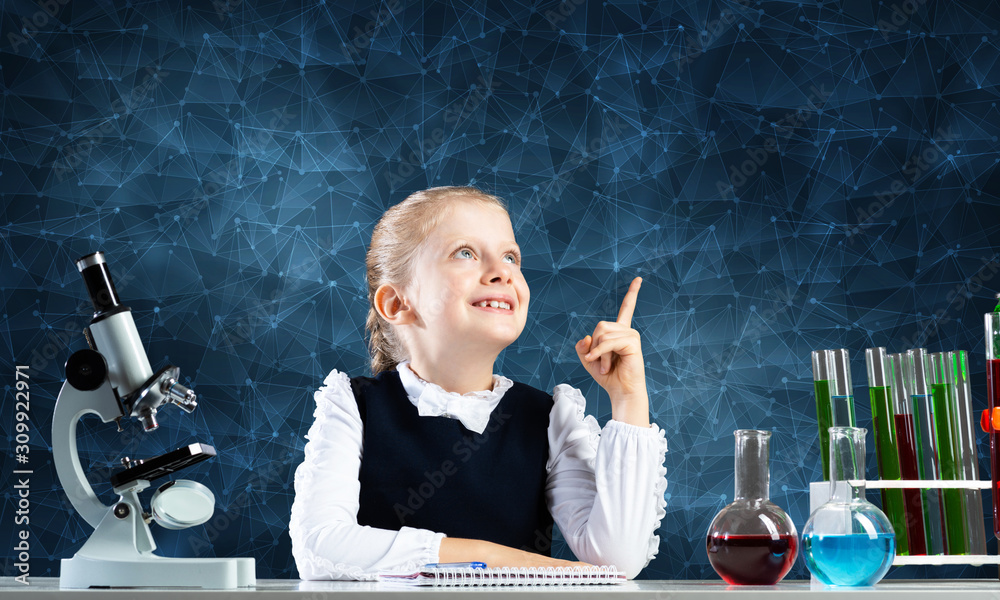 Little girl scientist sitting at desk