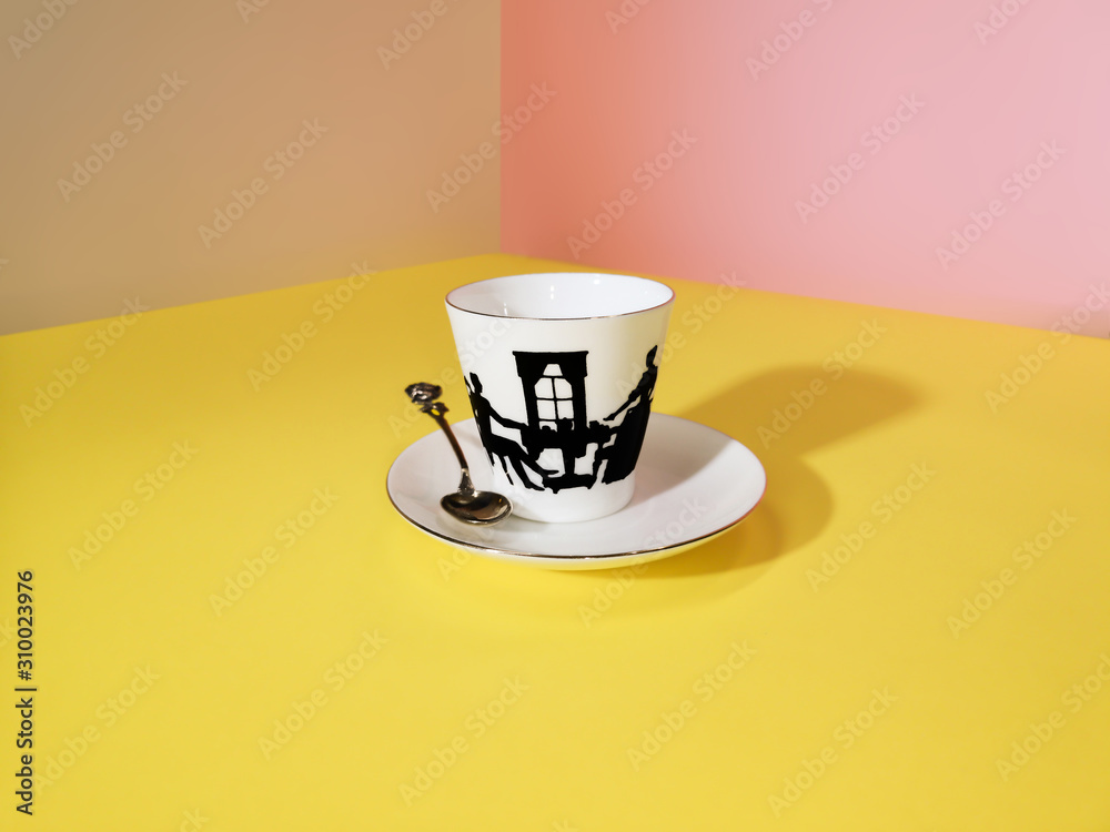 coffee cup with spoon on a yellow background