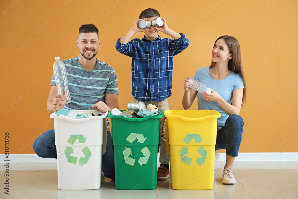 Happy family with containers for garbage on color background. Concept of recycling