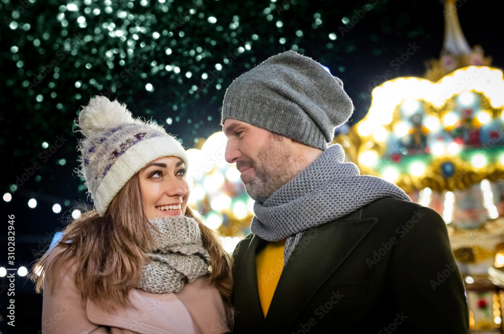 The couple spends the evening at a Christmas market full of light decorations