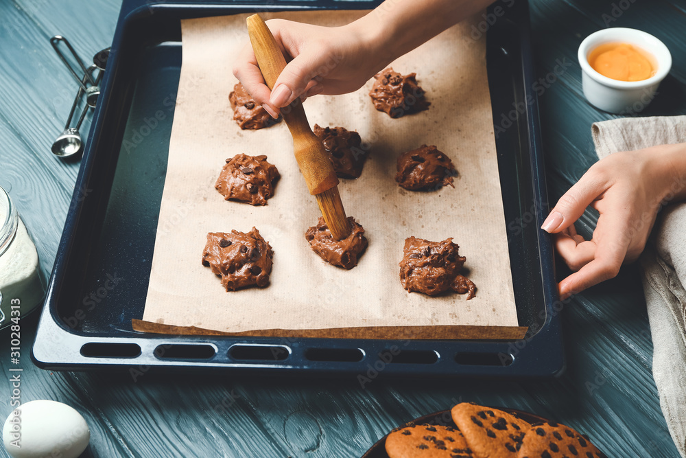 Woman baking tasty cookies with chocolate chips at home